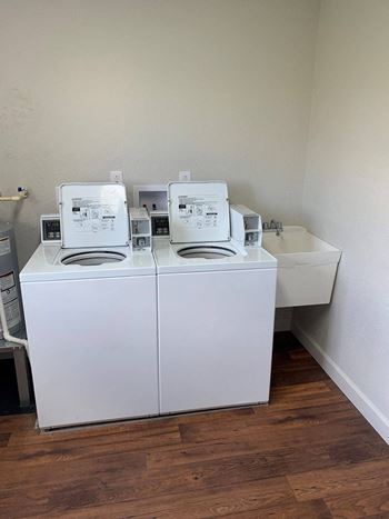 Two washing machines and a sink in a room